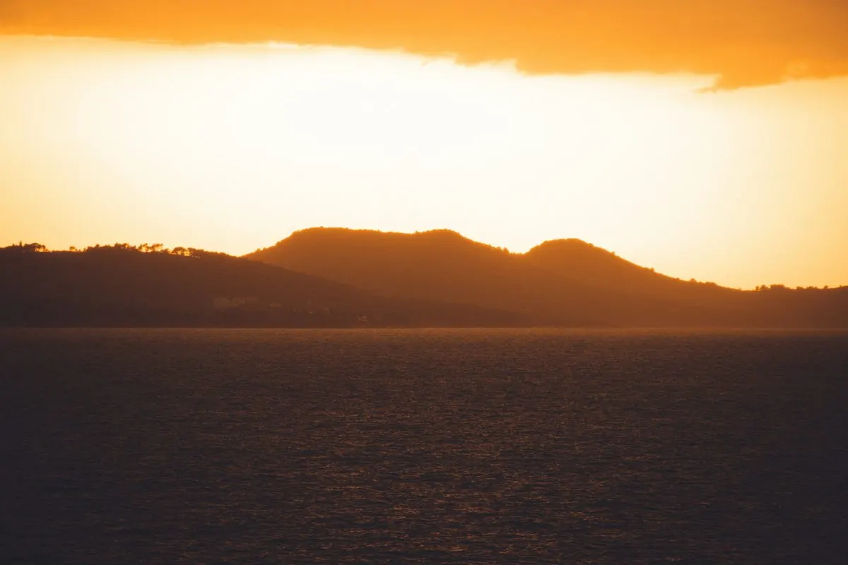 Sunset silhouette of Ugljan Island's hills seen across the water from the mainland